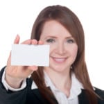 a smiling businesswoman holding empty card